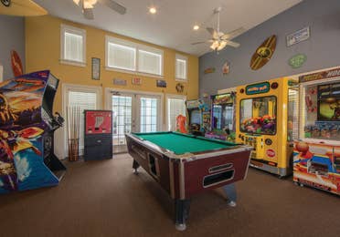 Arcade with a billiards table in the center of the room at Galveston Seaside Resort