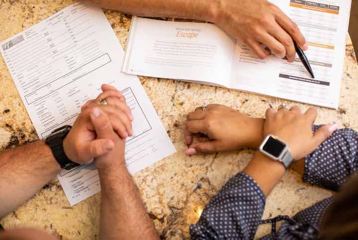 Three sets of hands going over details on their purchase