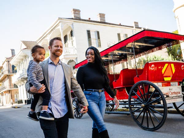 Mother, father and son walking past trolley near New Orleans Resort.