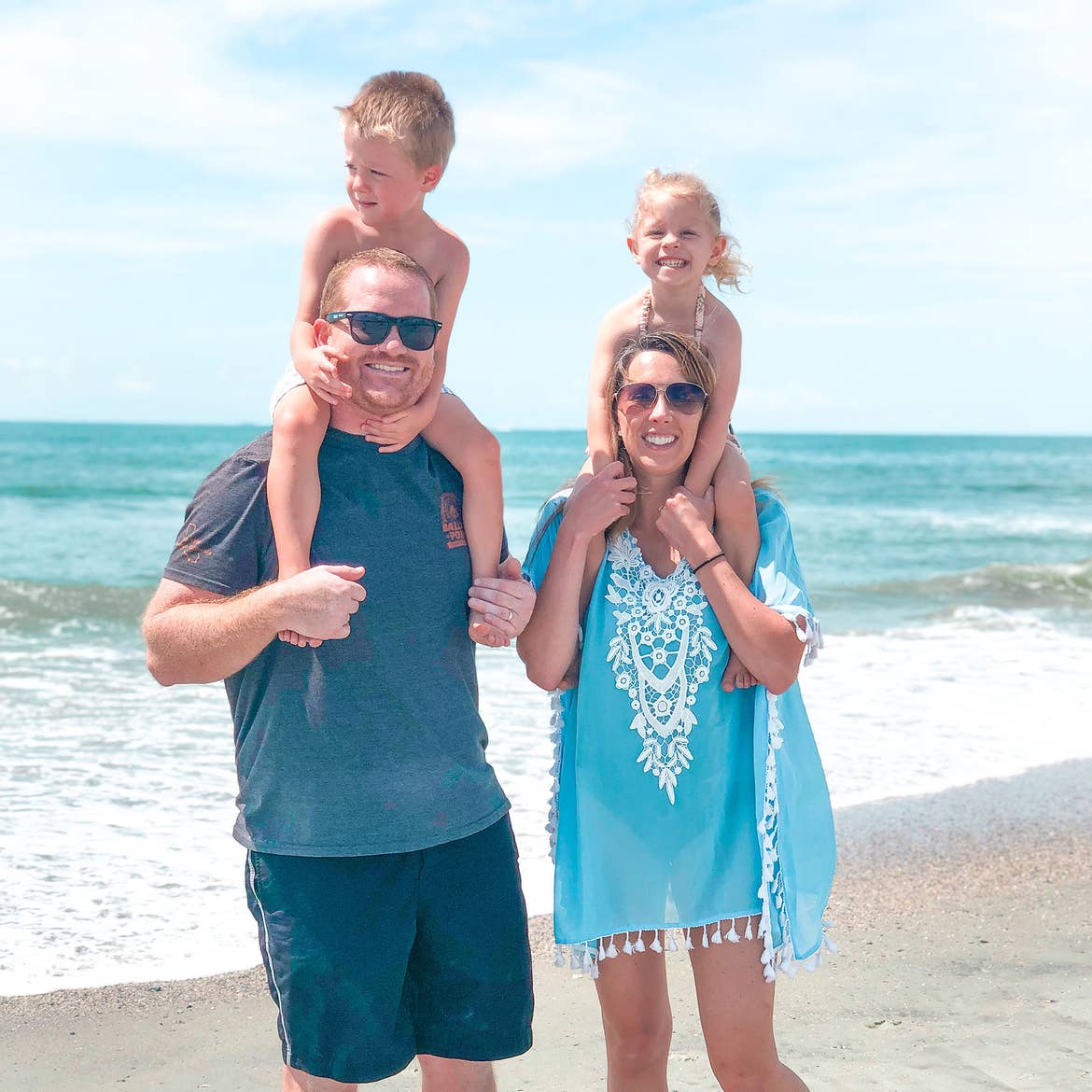Featured Contributor, Brianna Steele (bottom right) stands with her family on the white sands and shoreline of a beach.