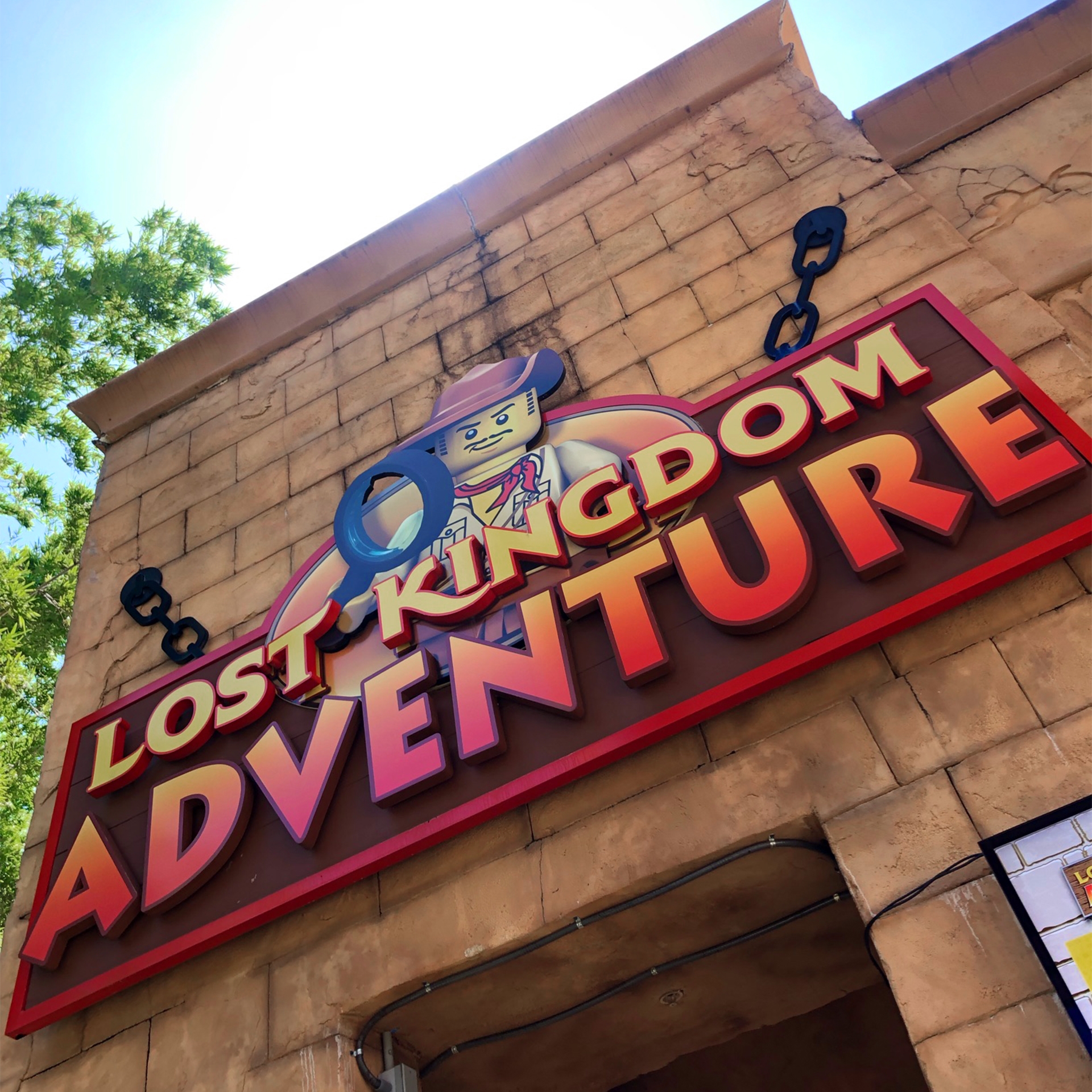 The exterior of an attraction made of brick with a marquee that reads, 'Lost Kingdom Adventure.'
