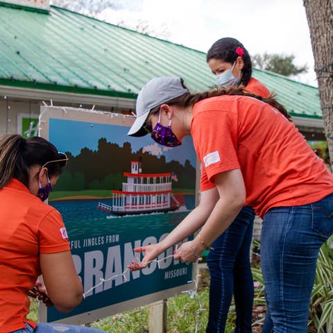 HICV Team Member help setup the festive decor outside of their Villa at Give Kids the World.