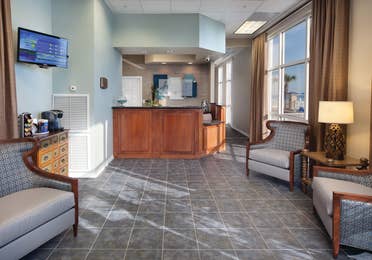 Lobby with reception desk, comfortable seating, and a flat screen TV at Panama City Beach Resort.