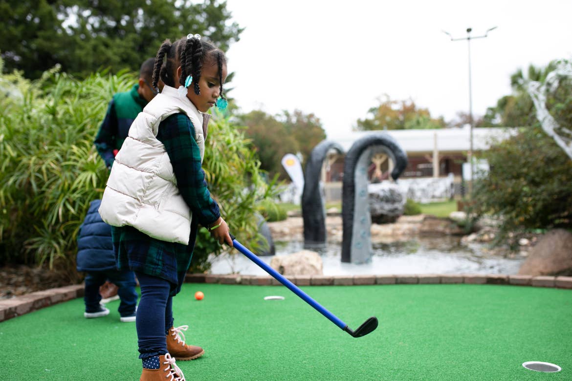Tina's daughter getting ready to hit her golf ball during spooky mini golf at Falladays at Villages Resort.
