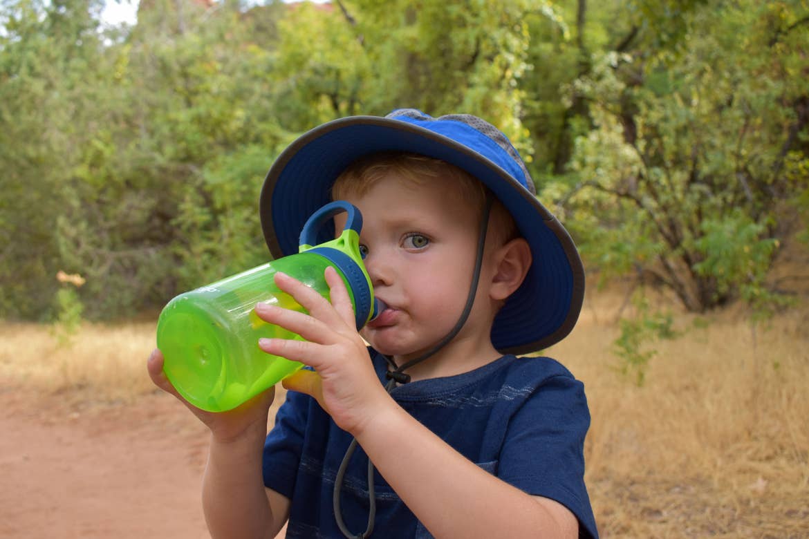 The youngest Averett stays hydrated and dressed to beat the desert heat with a blue sunhat and green water bottle.