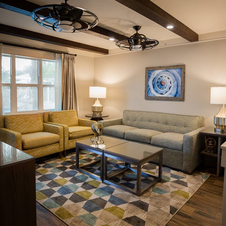 Living room with couch and two chairs in a two-bedroom Signature Collection villa at Cape Canaveral Beach Resort.