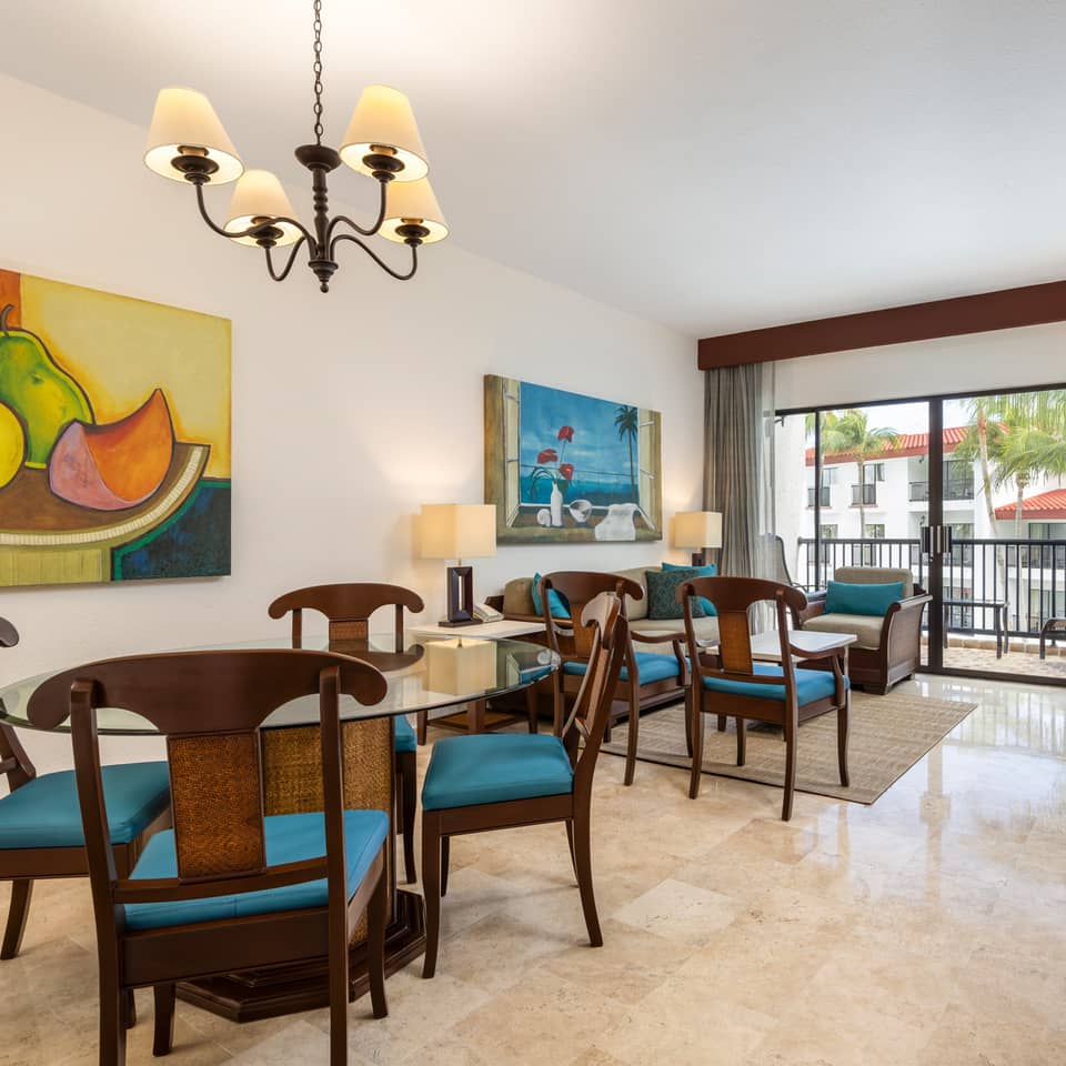 Two-bedroom Cancun suite with balcony and inviting living room.