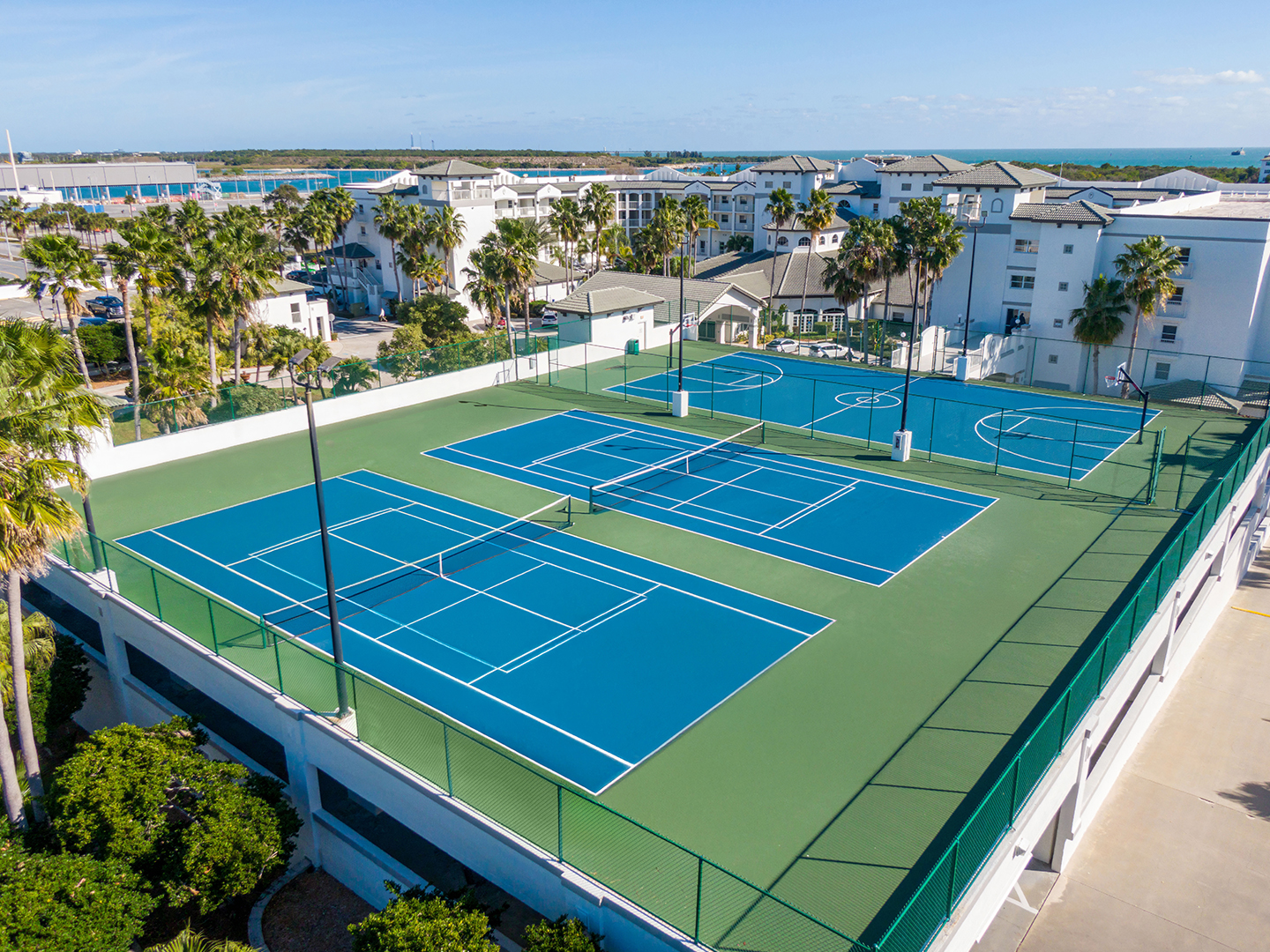 Aerial view of two tennis courts and a basketball court at Cape Canaveral Beach Resort.