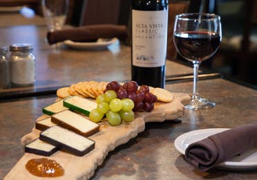 Cheese plate with cheeses, grapes and red wine.