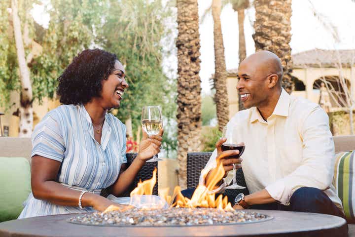Man and woman sitting outside and holding glasses of wine at Scottsdale Resort in Arizona