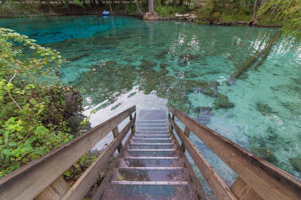 Stairs descending into crystal blue waters at Blue Spring State Park