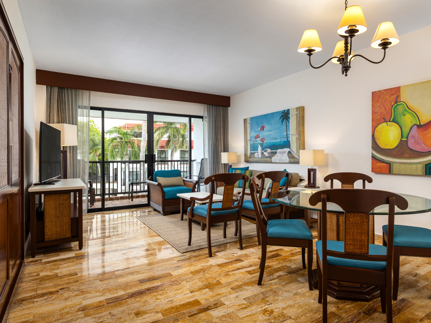 Villa living room with sofa, Murphy bed, dining area, and TV.