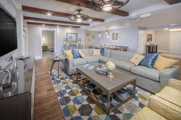 Living room with large sectional couch, two accent chairs and a flat screen TV in a two-bedroom Signature villa at Cape Canaveral Beach Resort