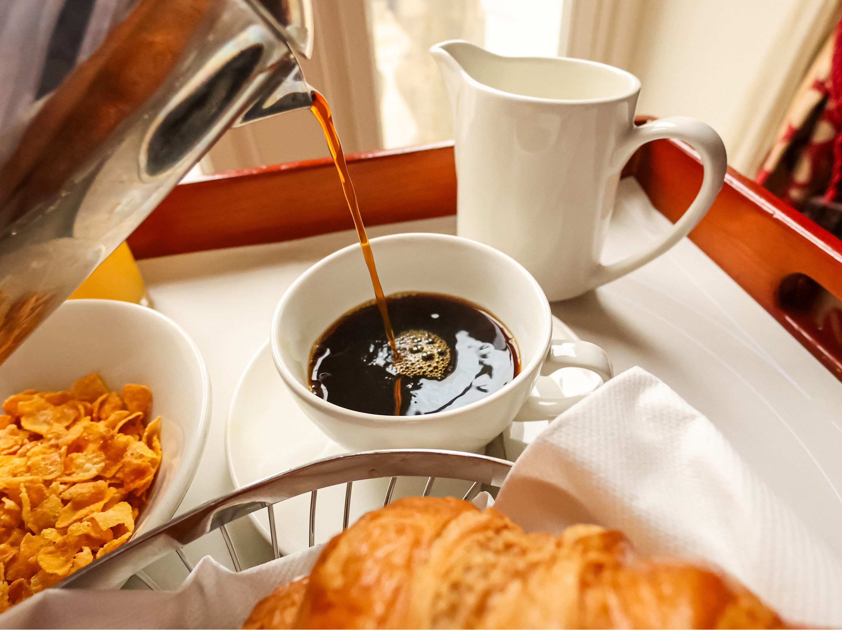 Coffee, cereal and pastries arranged on a breakfast tray, representing room service at Le Sel. 