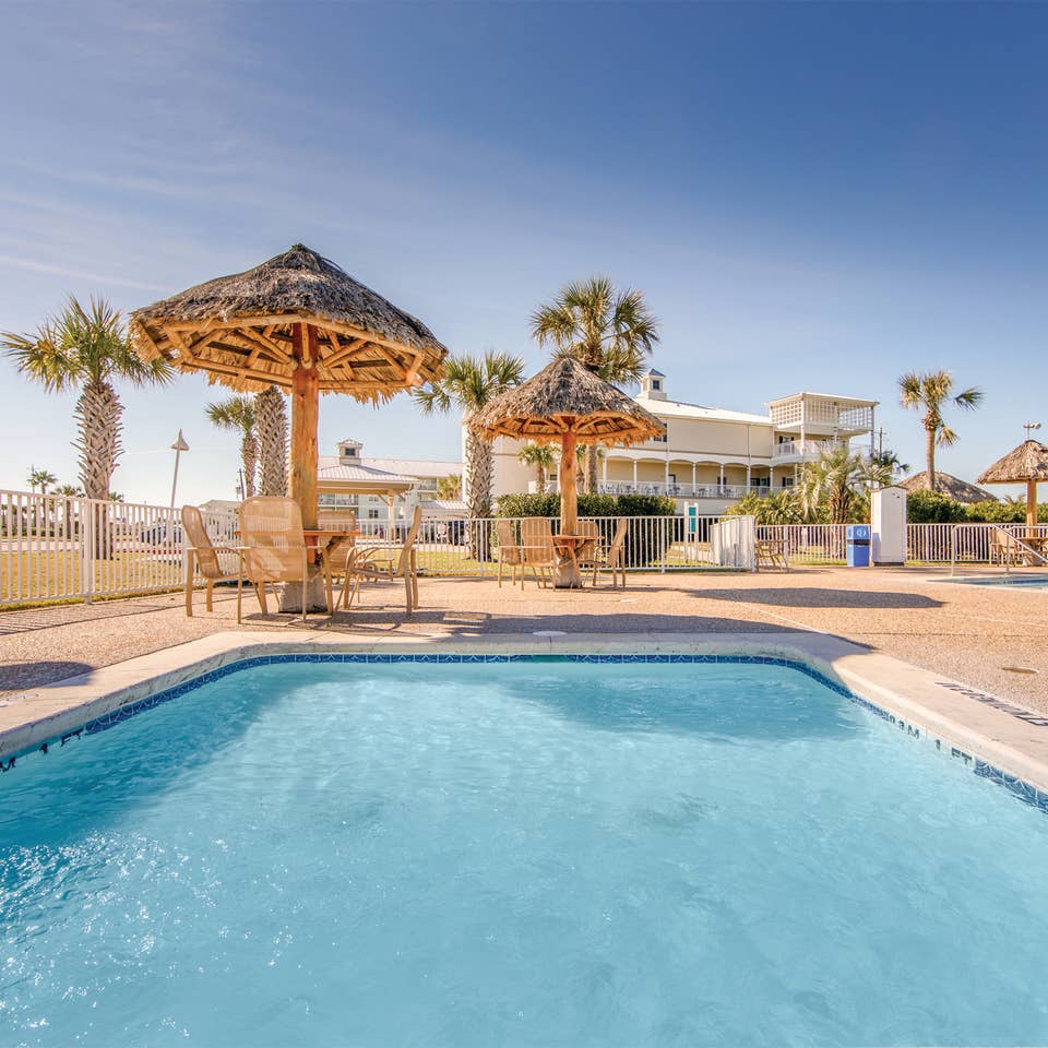 Outdoor pool surrounded by palm trees at Galveston Seaside Resort.