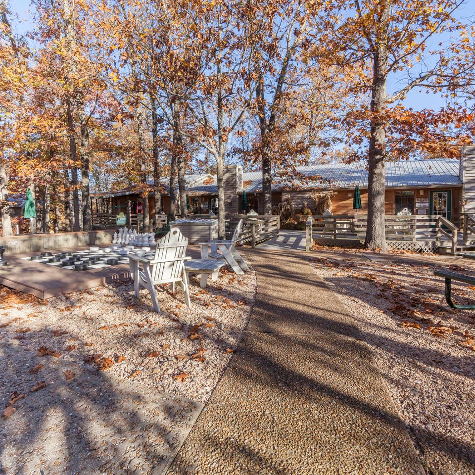 Outdoor picnic tables surrounded by trees at Ozark Mountain Resort in Kimberling City, MO.