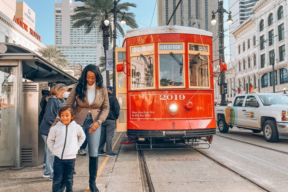 Featured Contributor, Sally Butan (left) of @butanclan stands with her son (left) in front of a streetcar outside the entrance of our resort in New Orleans, Louisiana.