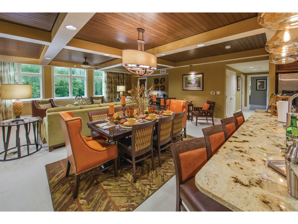 Elegant villa dining and living room with warm tones and modern decor.