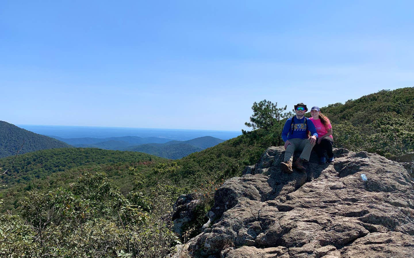 Featured Contributor, Ashley Fraboni (right) and Fiancé, Nicholas (left) sit atop a rock a Shenandoah National Park.