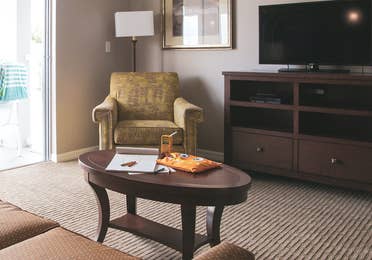 Living room with couch, chair and flat screen TV in a two-bedroom villa at Orlando Breeze Resort in Florida.