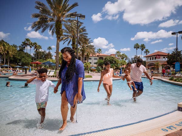 Family of four walking out of zero-entry pool at Orange Lake Resort near Orlando, Florida.
