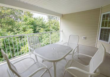 Balcony with table and four chairs in a two-bedroom presidential villa at Fox River Resort in Sheridan, Illinois.
