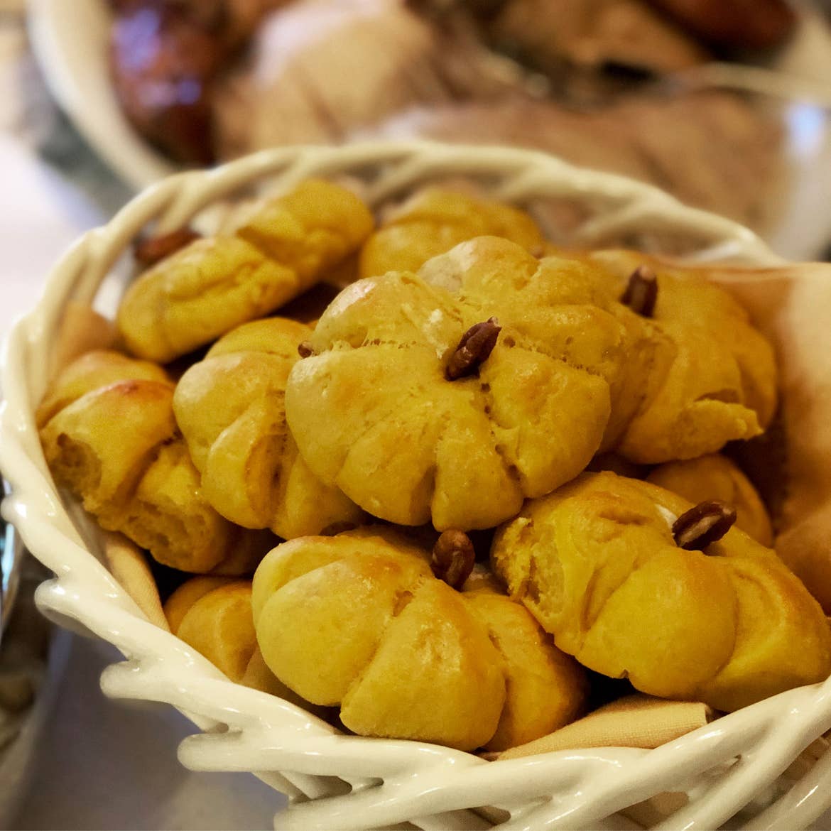 Jennifer Harmon's pumpkin-shaped yeast rolls sit in a festive basket on a dining room table.