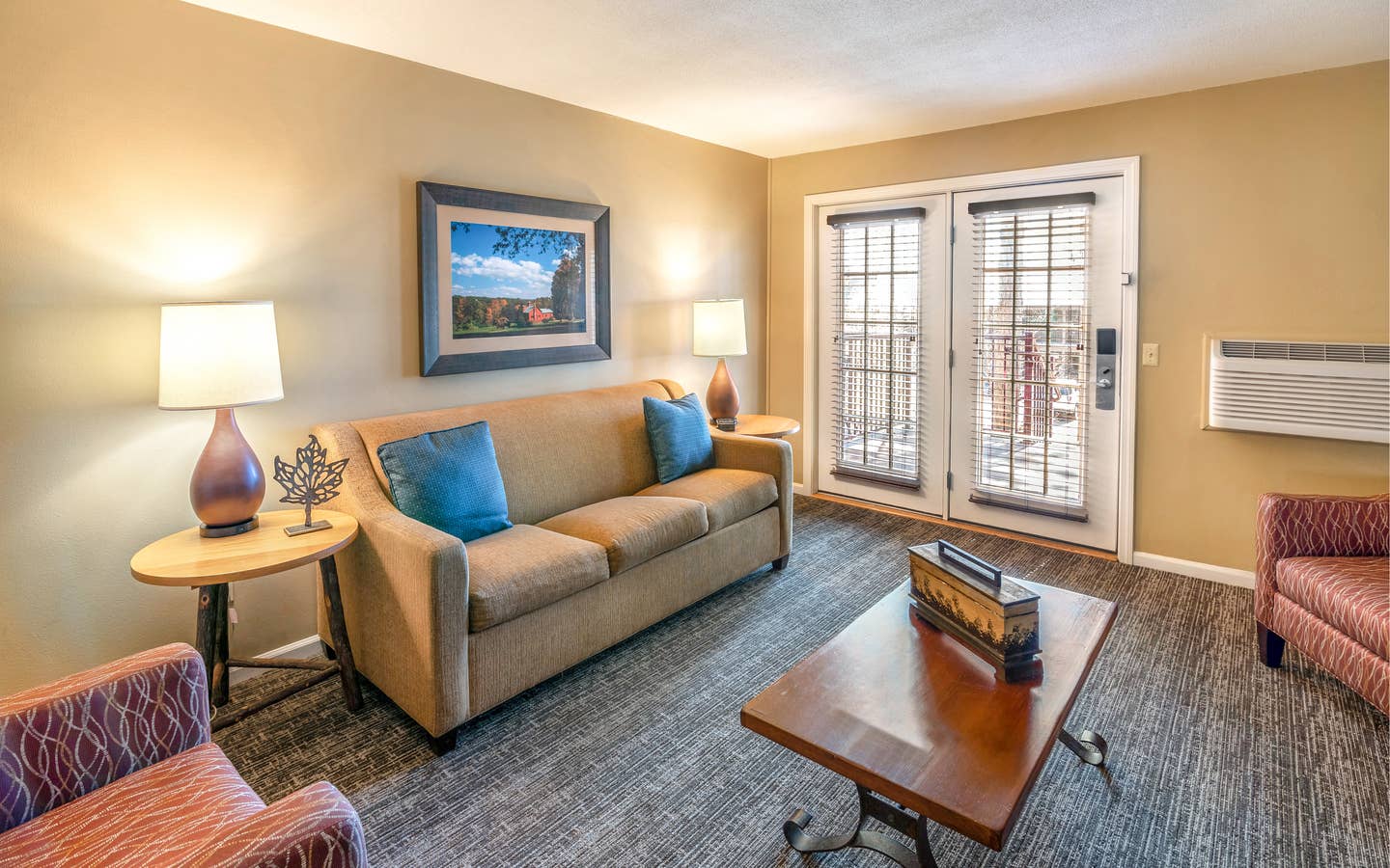 Living room with a sofa, two chairs, and tables in a one bedroom villa at Oak n' Spruce Resort in South Lee, Massachusetts