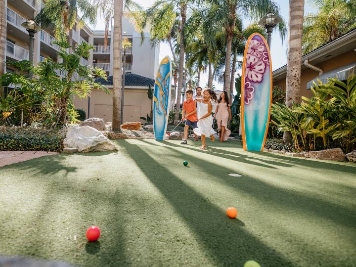 Family playing mini golf at Cape Canaveral Beach Resort in Florida.