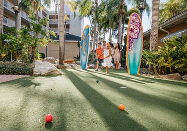 Family playing mini golf at Cape Canaveral Beach Resort in Florida.