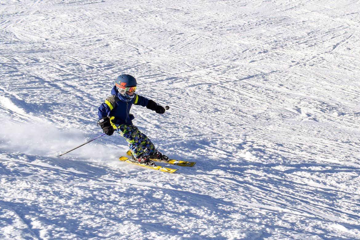 Contributor, Jessica Averett's son clad in winter and skiing gear ascends down the slopes.