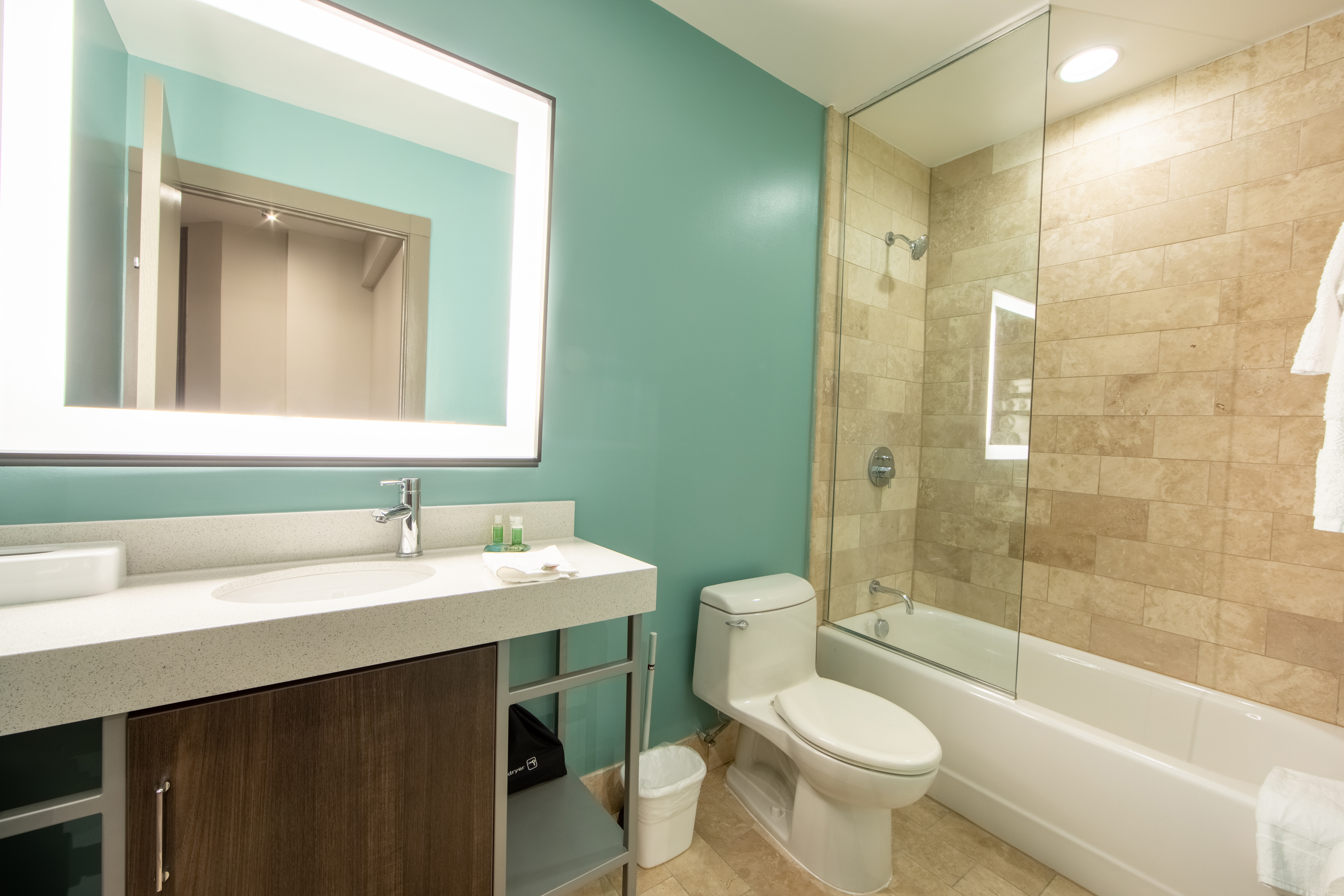 One bedroom villa bathroom with shower/tub combination, toilet and sink with lighted mirror at New Orleans Resort in Louisiana.