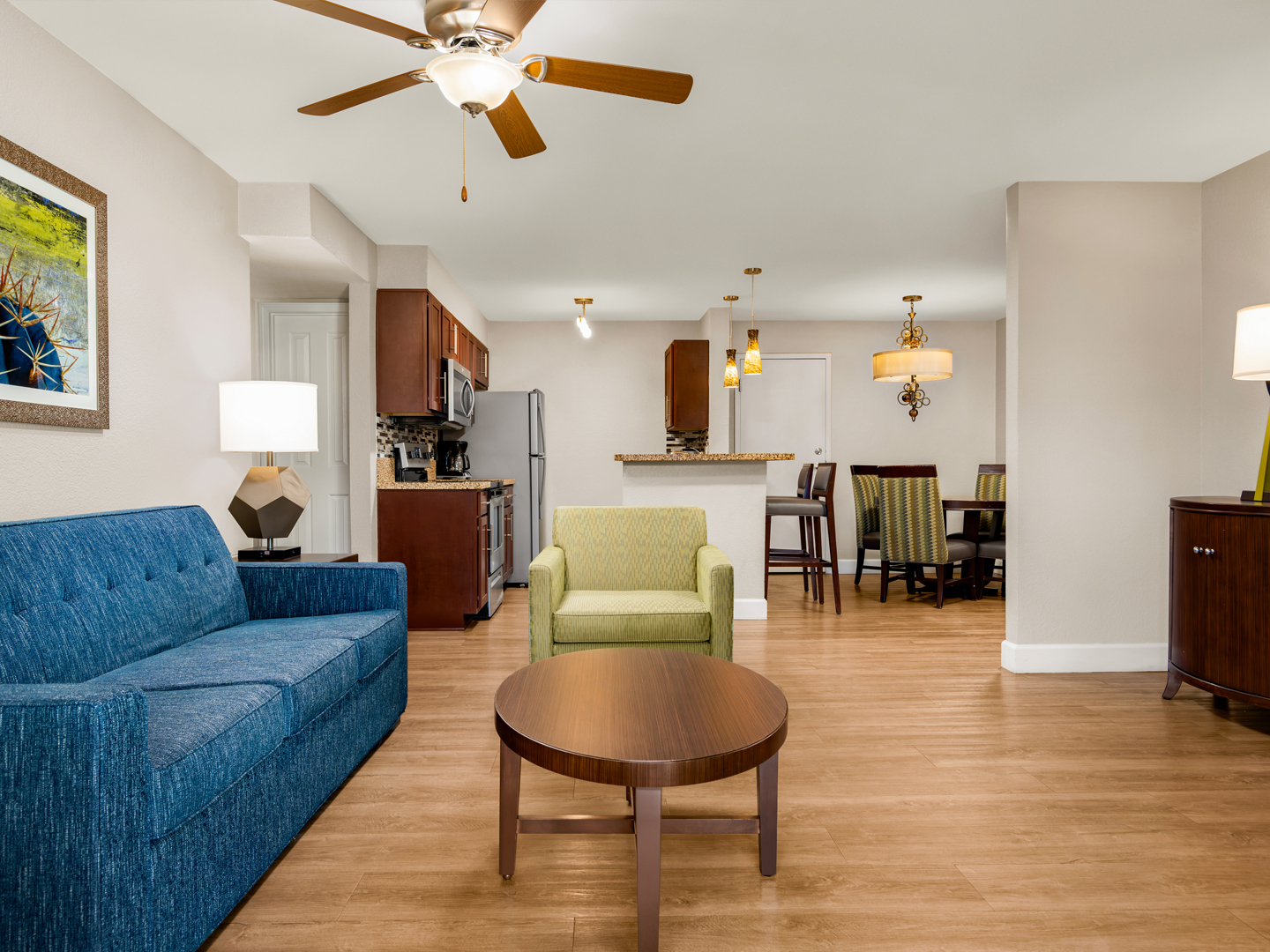 Bright living room with sofa, chairs, and balcony view.
