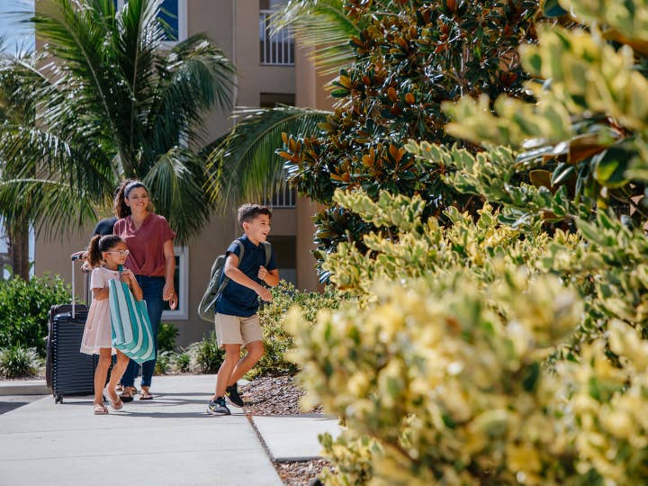 Family arriving at Cape Canaveral Beach Resort with luggage in Florida.