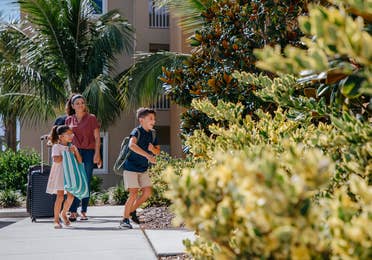 Family arriving at Cape Canaveral Beach Resort with luggage in Florida.