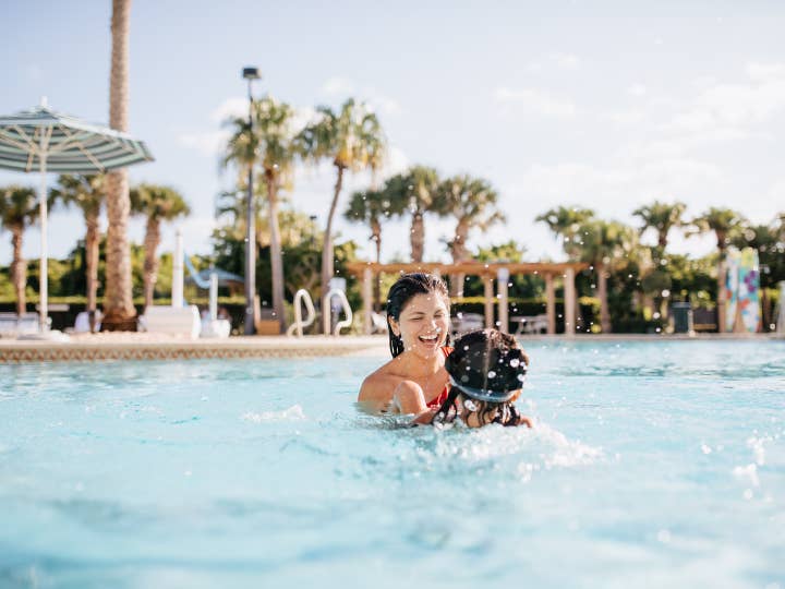 Mother and child swimming in pool at Cape Canaveral Beach Resort in Florida.