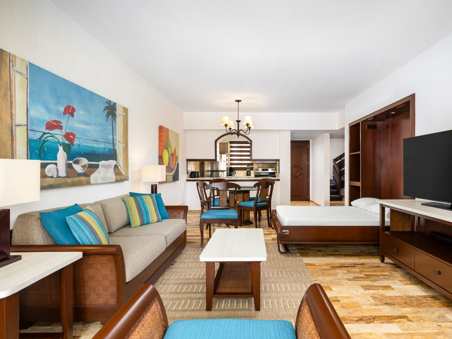 Suite living room with sofa, dining area, and TV. 