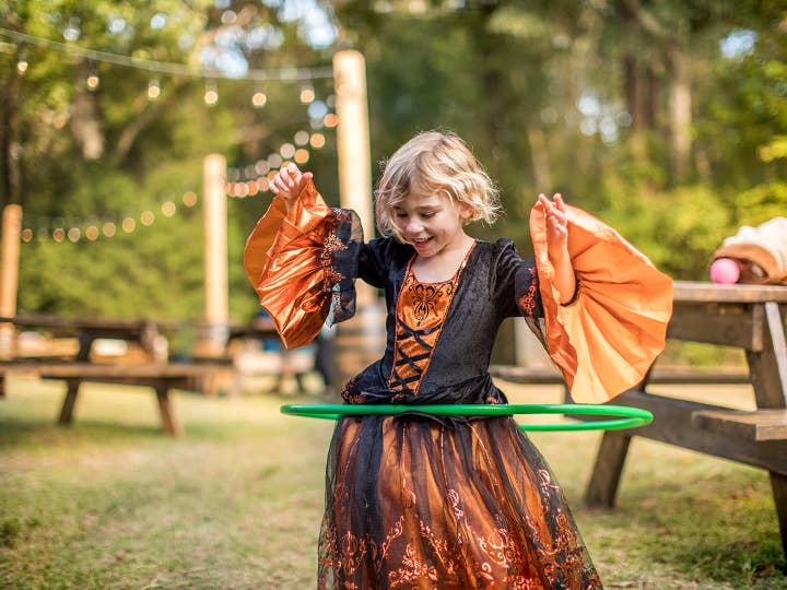 Young child in a Halloween costume hula-hooping at Falladays.