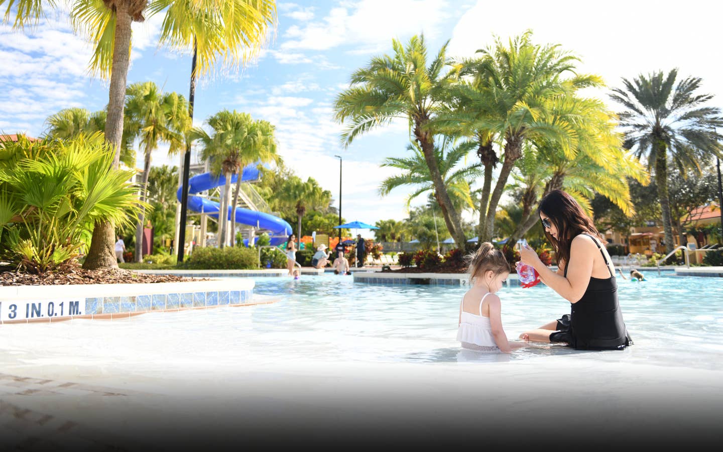 Adult and child sitting in zero-entry pool at Orange Lake Resort near Orlando, Florida.