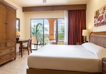 Large garden-view bedroom opening to a balcony with soaking tub.