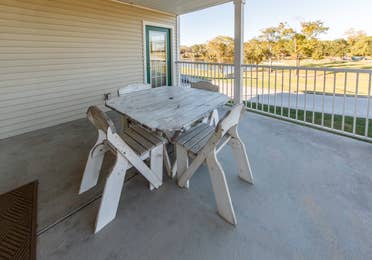 Furnished balcony with table and four chairs in a presidential two bedroom villa at Piney Shores Resort in Conroe, Texas
