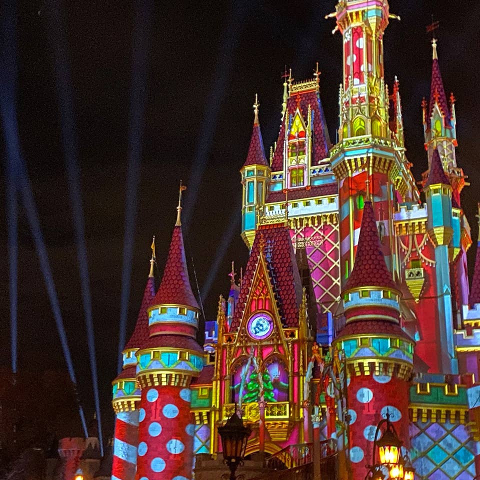 Cinderella's Castle at Magic Kingdom Park at Walt Disney World® Resort is illuminated with holiday projections at night.