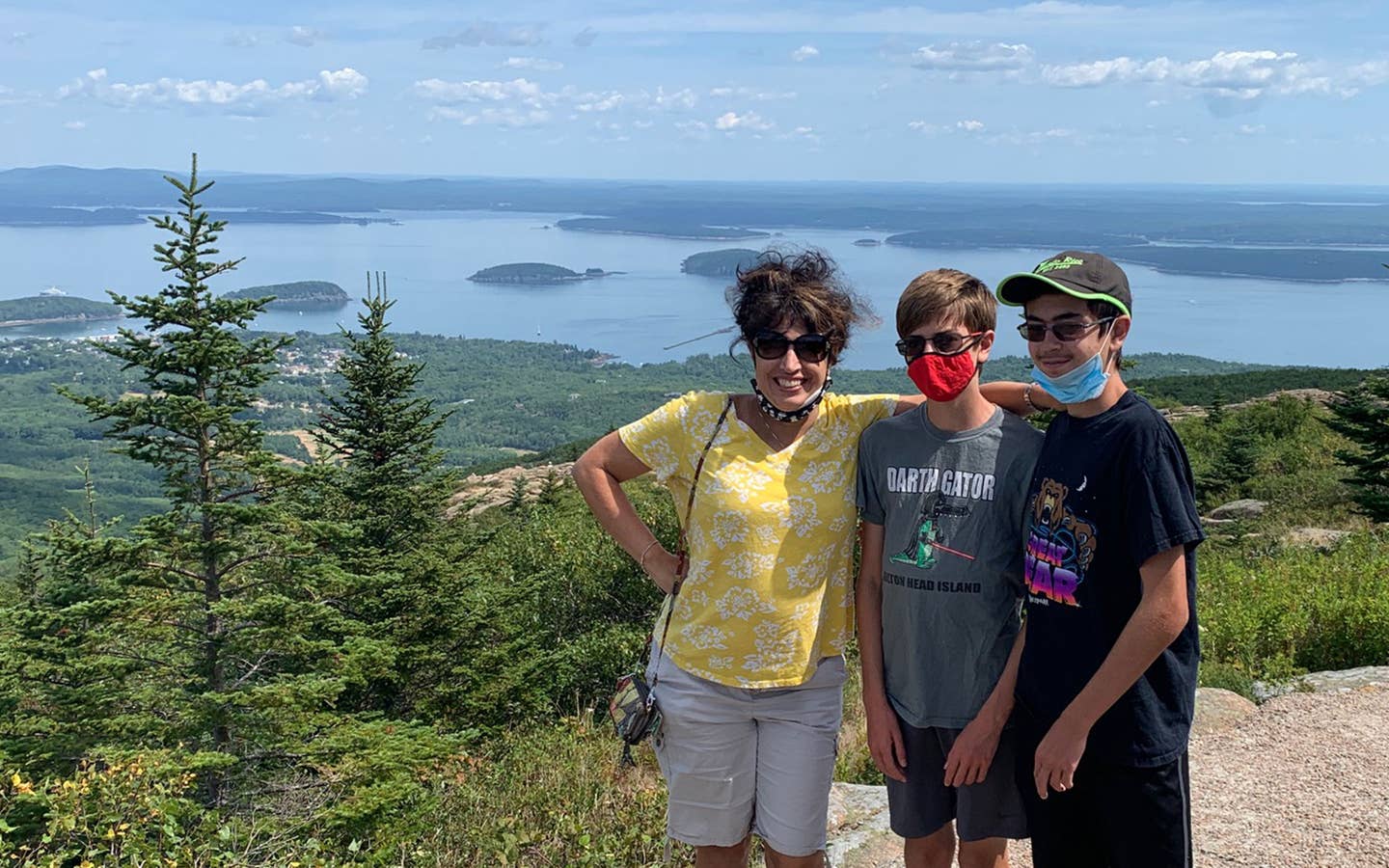 Author, Jennifer Probst (left), and her sons (middle and right) stand on the edge of the Acadia National Park hiking trail while wearing their masks.