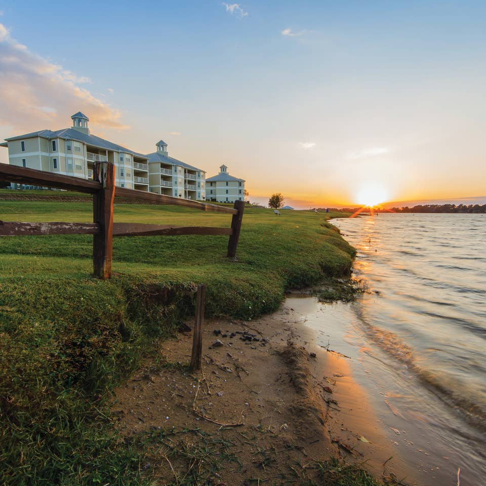 View of property buildings near water at Piney Shores Resort in Conroe, Texas.
