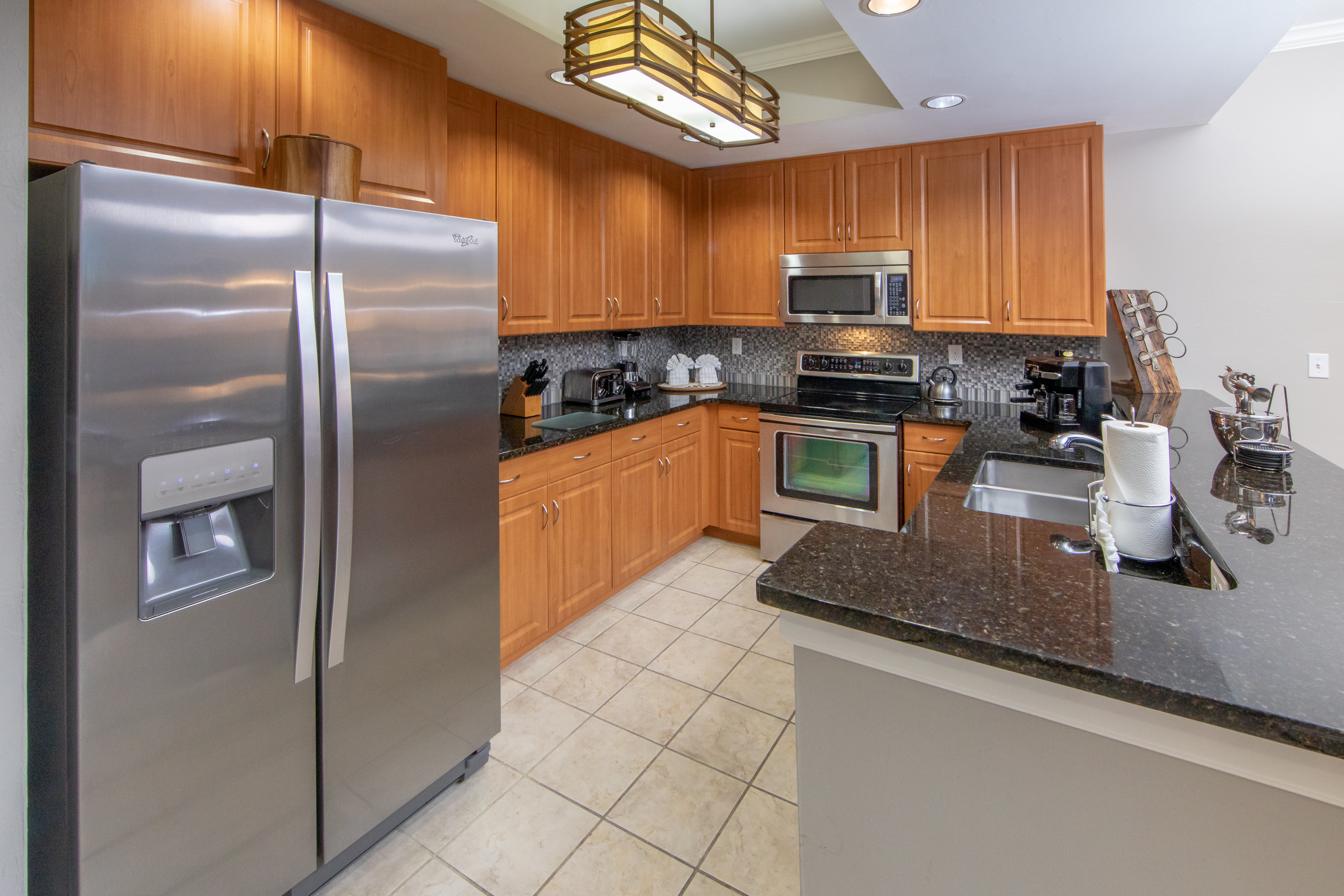 Full kitchen with stainless steel appliances in a three-bedroom villa at Sunset Cove Resort in Marco Island, Florida