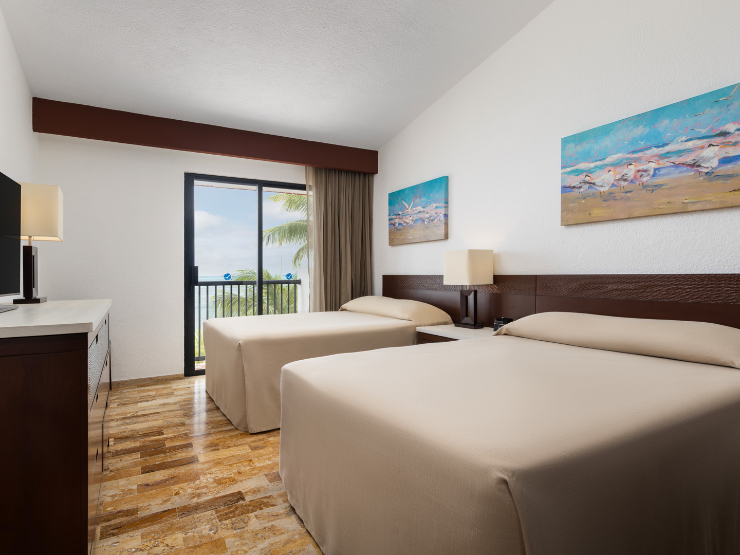 Oceanview villa bedroom with two beds and balcony access.