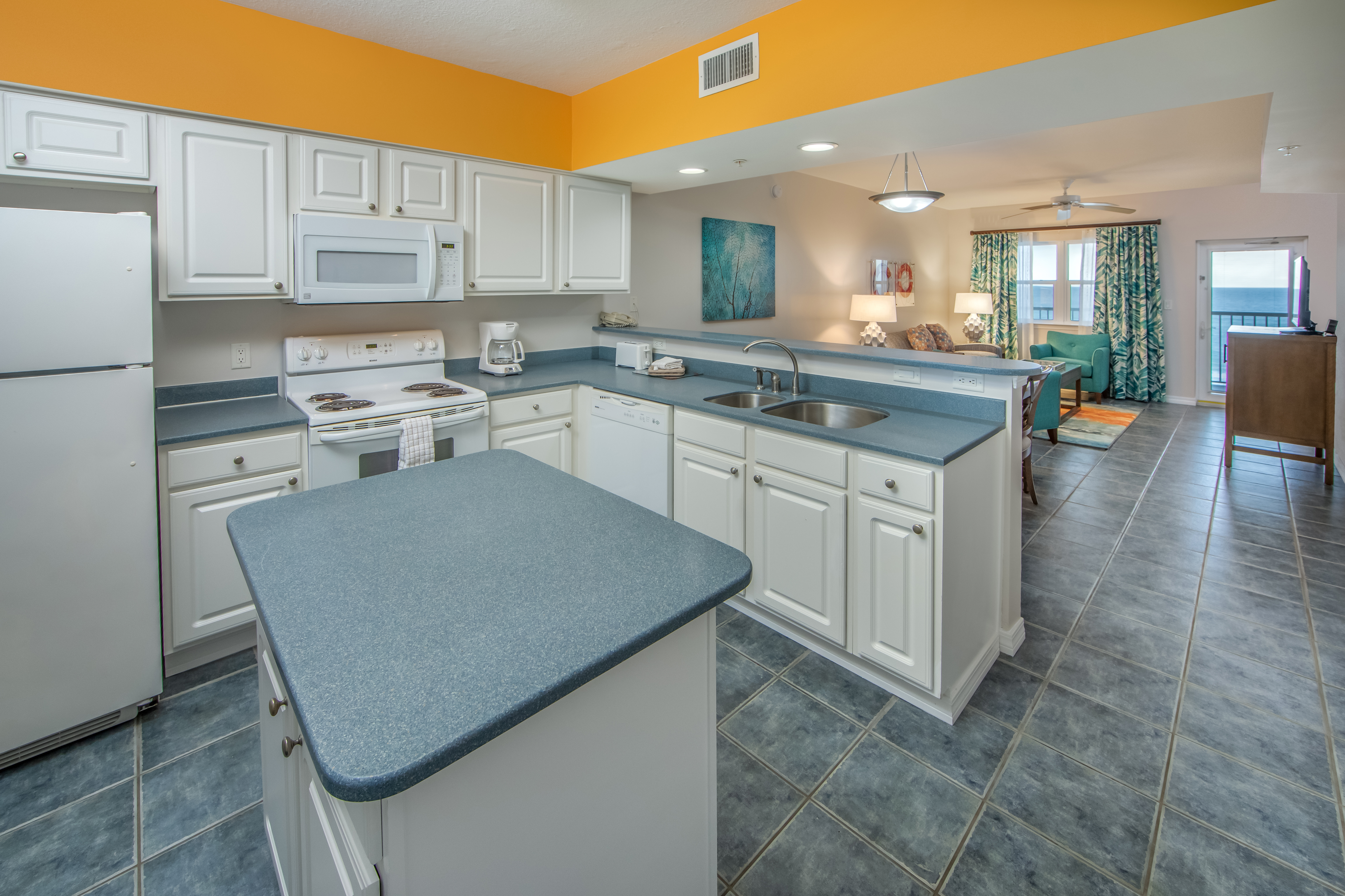 Kitchen with island, fridge, oven, microwave, dishwasher, and sink in a two-bedroom villa at Panama City Beach Resort