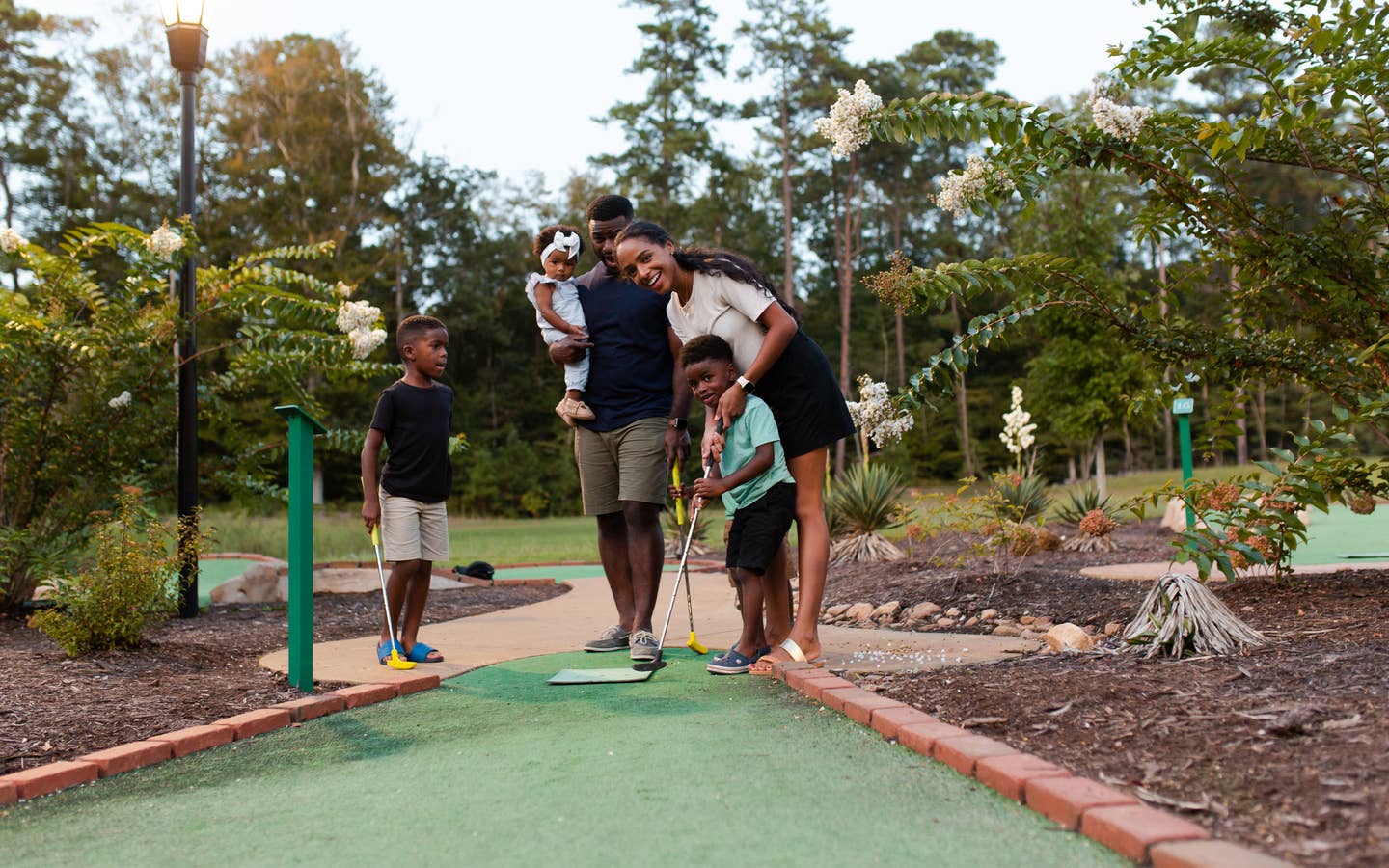 Family of five playing outdoor mini golf at Williamsburg Resort.
