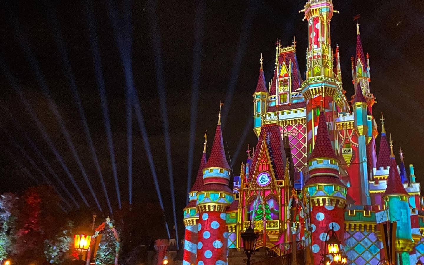 Cinderella's Castle at Magic Kingdom Park at Walt Disney World® Resort is illuminated with holiday projections at night.