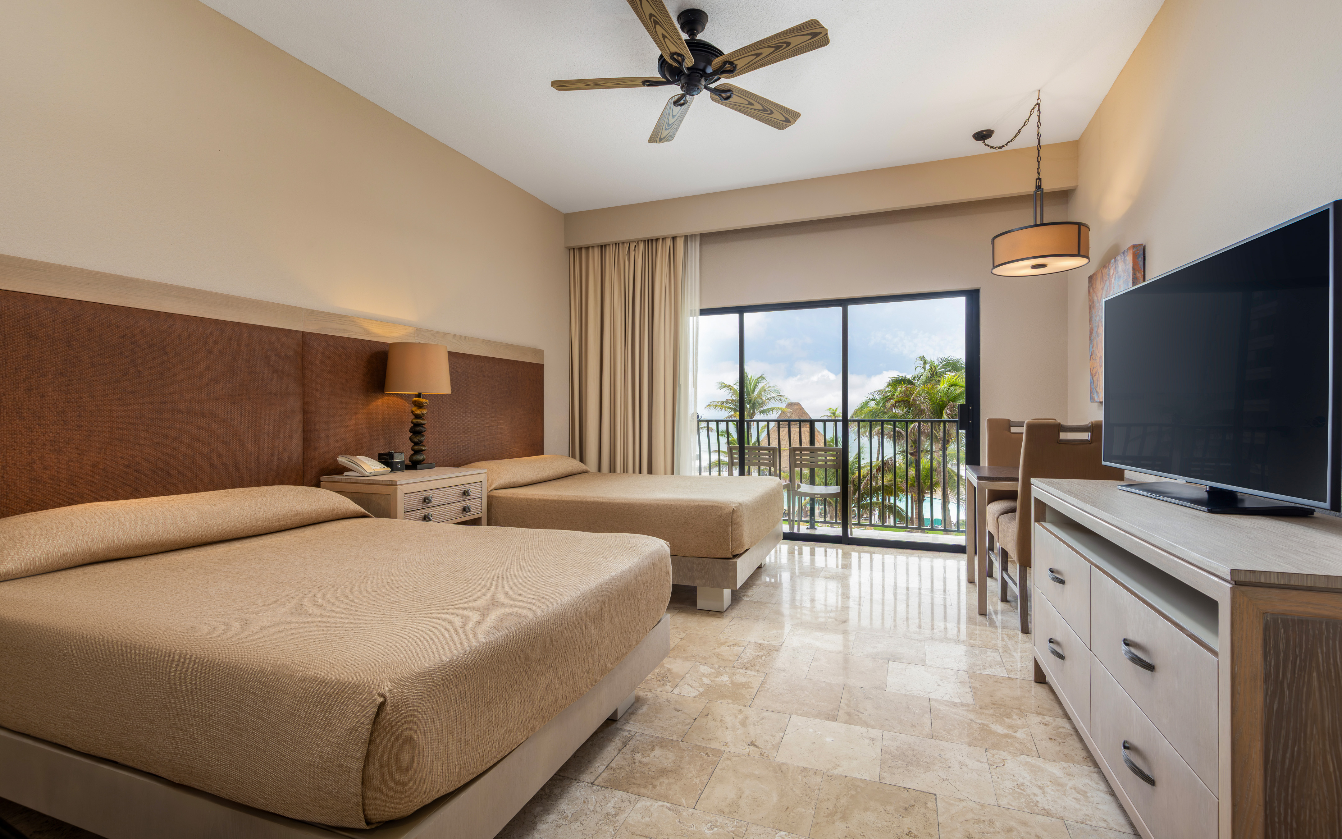 Oceanview guestroom with two beds and a private balcony.
